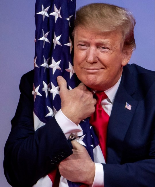 President Trump hugs the American flag and we have no idea why